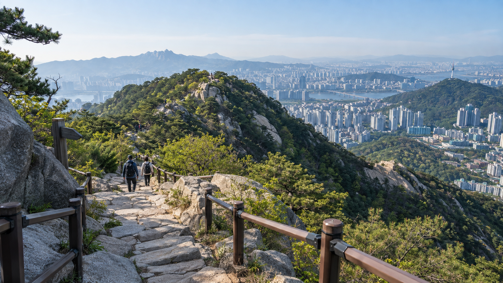 Hikers walking from a Seoul neighborhood toward a forested mountain trail.